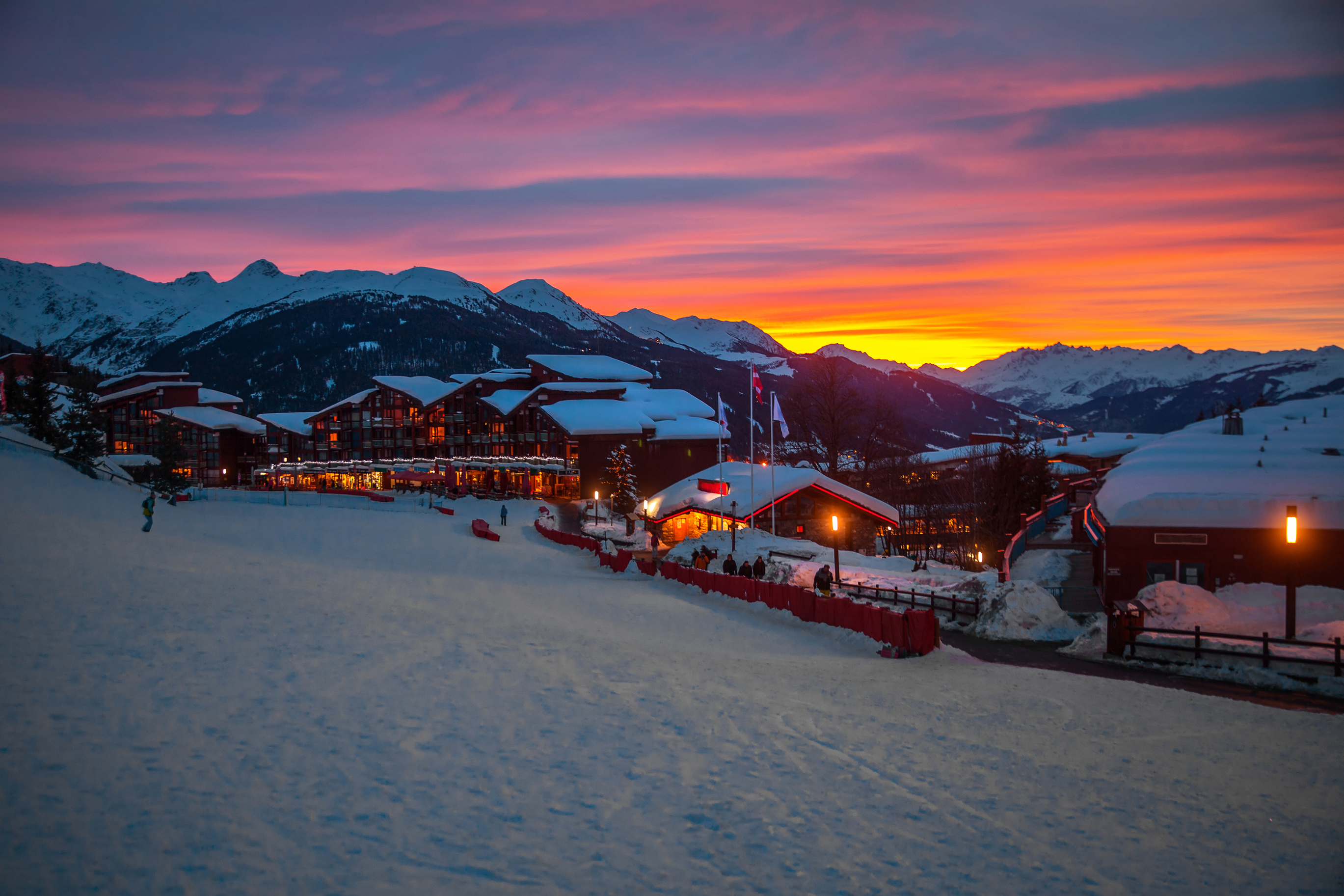 Arc 1800 in Les Arcs at sunset, with snow-covered resort buildings and mountains